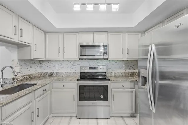a kitchen with cabinets stainless steel appliances and a sink