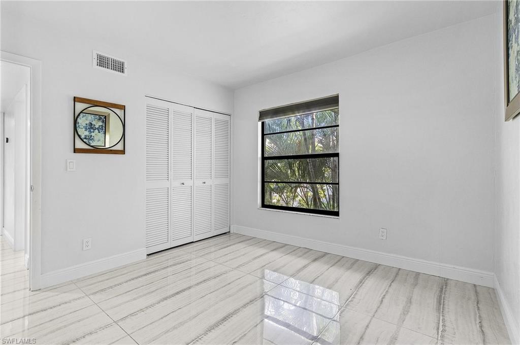 1765 Courtyard Way, Unit C202 Naples, FL 34112 - Photo 12 of 25 Unfurnished bedroom with baseboards and a closet