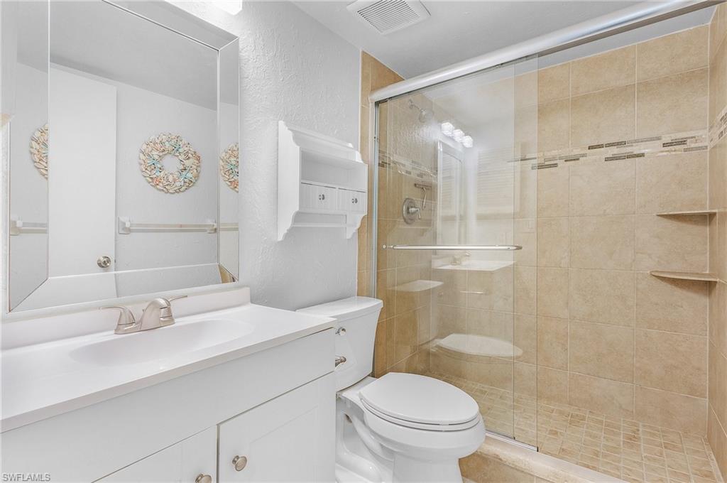 1765 Courtyard Way, Unit C202 Naples, FL 34112 - Photo 13 of 25 Bathroom with a textured wall, vanity, and a stall shower