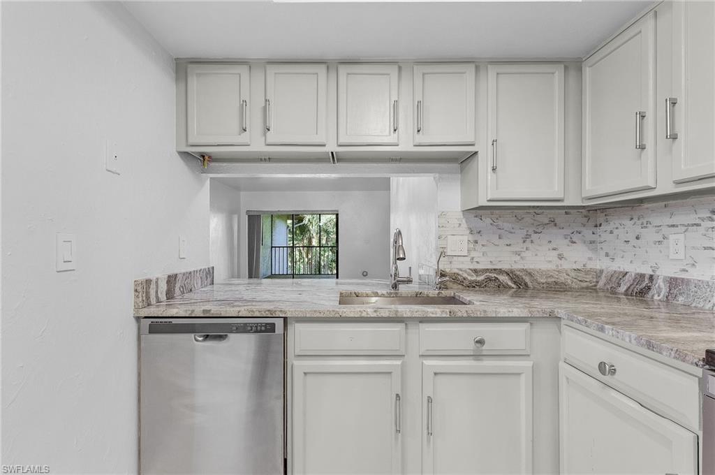 1765 Courtyard Way, Unit C202 Naples, FL 34112 - Photo 2 of 25 Kitchen with dishwasher, white cabinets, and tasteful backsplash