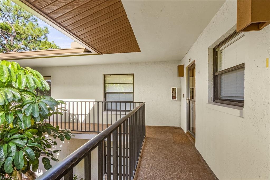 1765 Courtyard Way, Unit C202 Naples, FL 34112 - Photo 4 of 25 Hallway with carpet floors and a textured wall