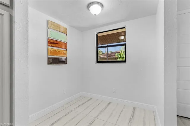 an empty room with windows and wall painting