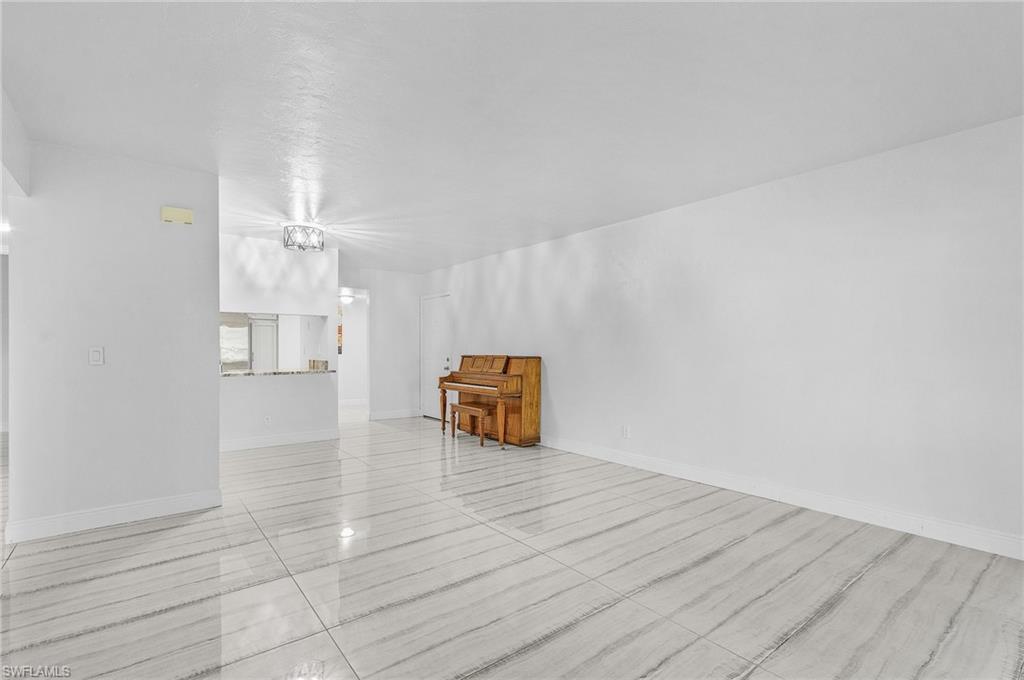 1765 Courtyard Way, Unit C202 Naples, FL 34112 - Photo 10 of 25 Unfurnished living room with baseboards