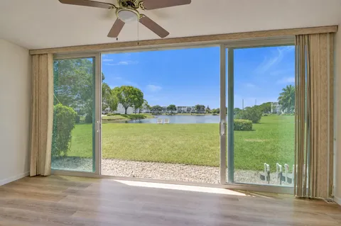 a view of a room with a large window and wooden floor