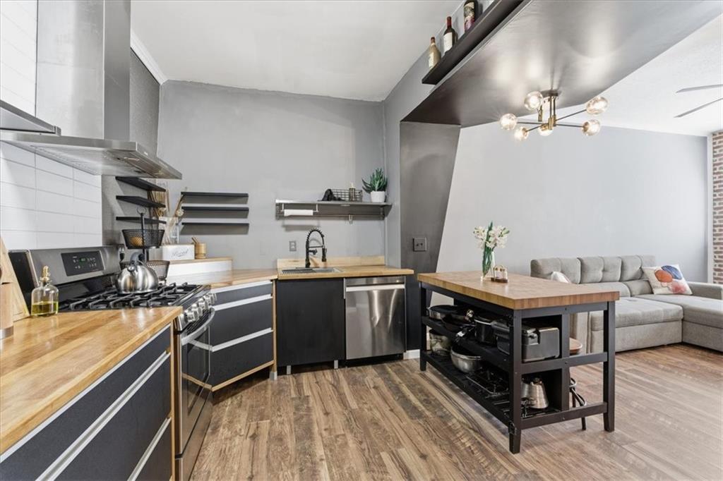 343 8th Street Northeast, Unit T1 Atlanta, GA 30309 - Photo 13 of 33 a kitchen with stainless steel appliances a stove a sink dishwasher and cabinets with wooden floor