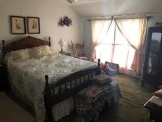 a bed sitting in a bedroom next to a window