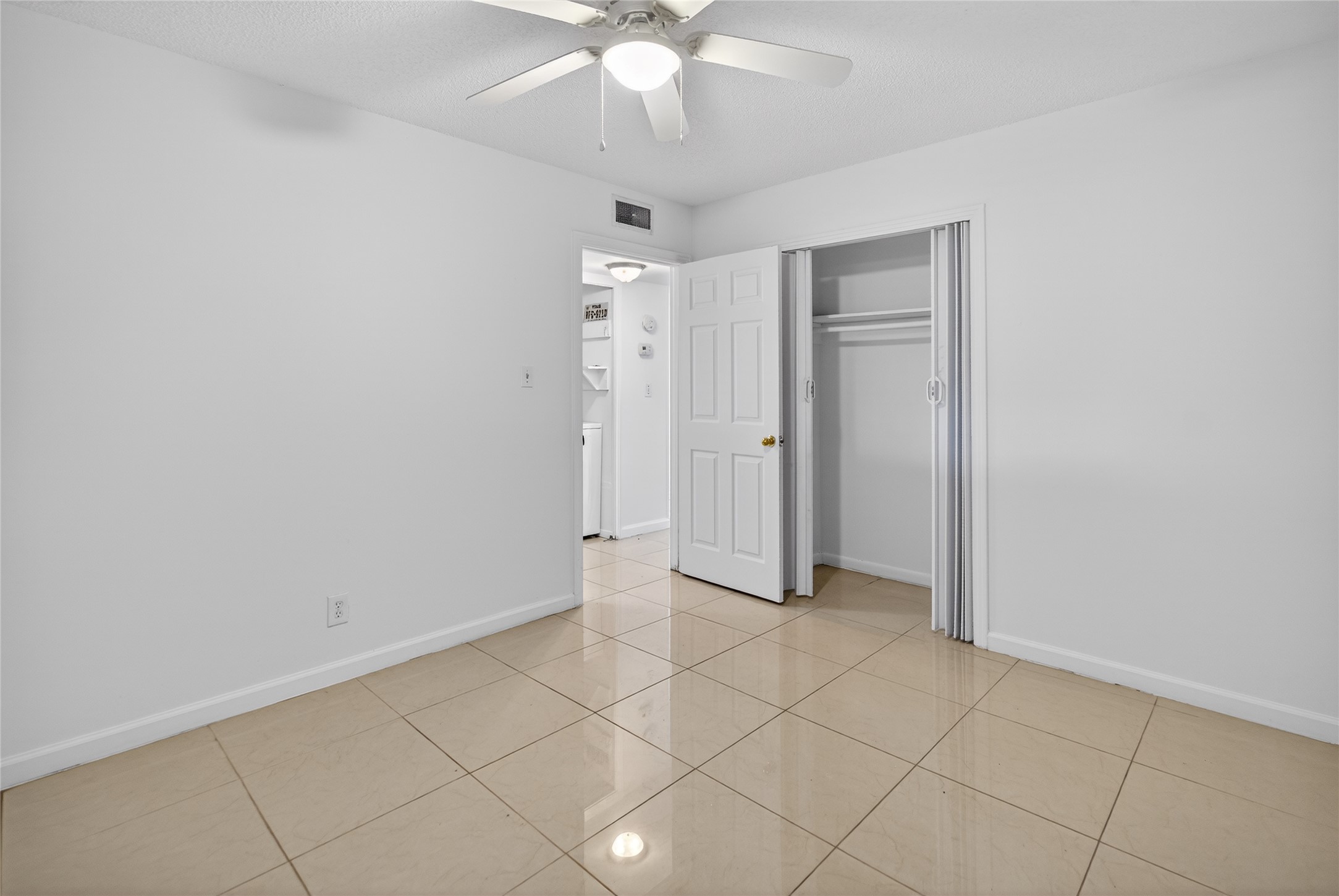 1400 Braes Ridge Drive, Unit B Austin, TX 78723 - Photo 15 of 16 Unfurnished bedroom with ceiling fan, a closet, and light tile patterned flooring