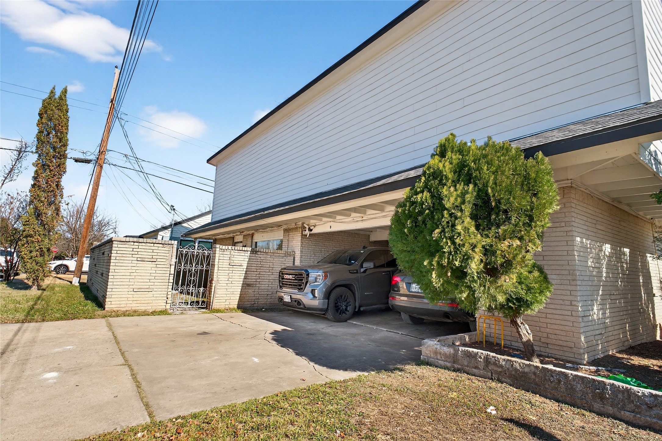 1400 Braes Ridge Drive, Unit B Austin, TX 78723 - Photo 2 of 16 View of home's exterior featuring brick siding, a gate, a carport, and concrete driveway