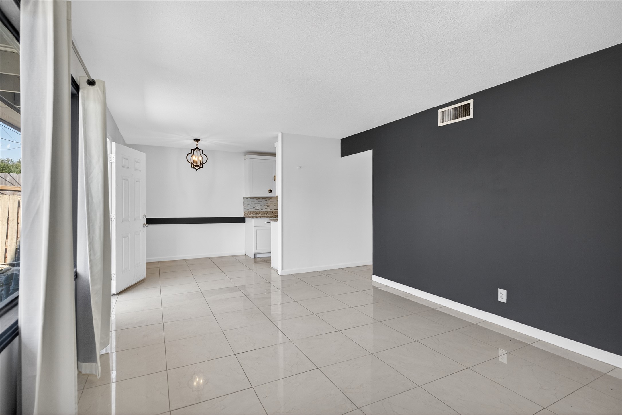 1400 Braes Ridge Drive, Unit B Austin, TX 78723 - Photo 7 of 16 Empty room featuring suspended lighting and light tile patterned flooring