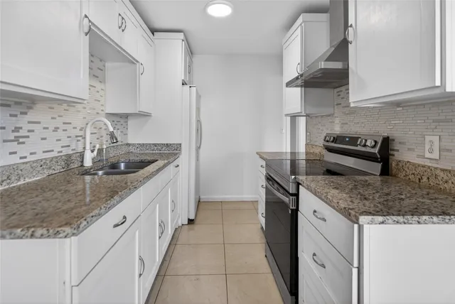 a kitchen with stainless steel appliances granite countertop a sink stove and cabinets