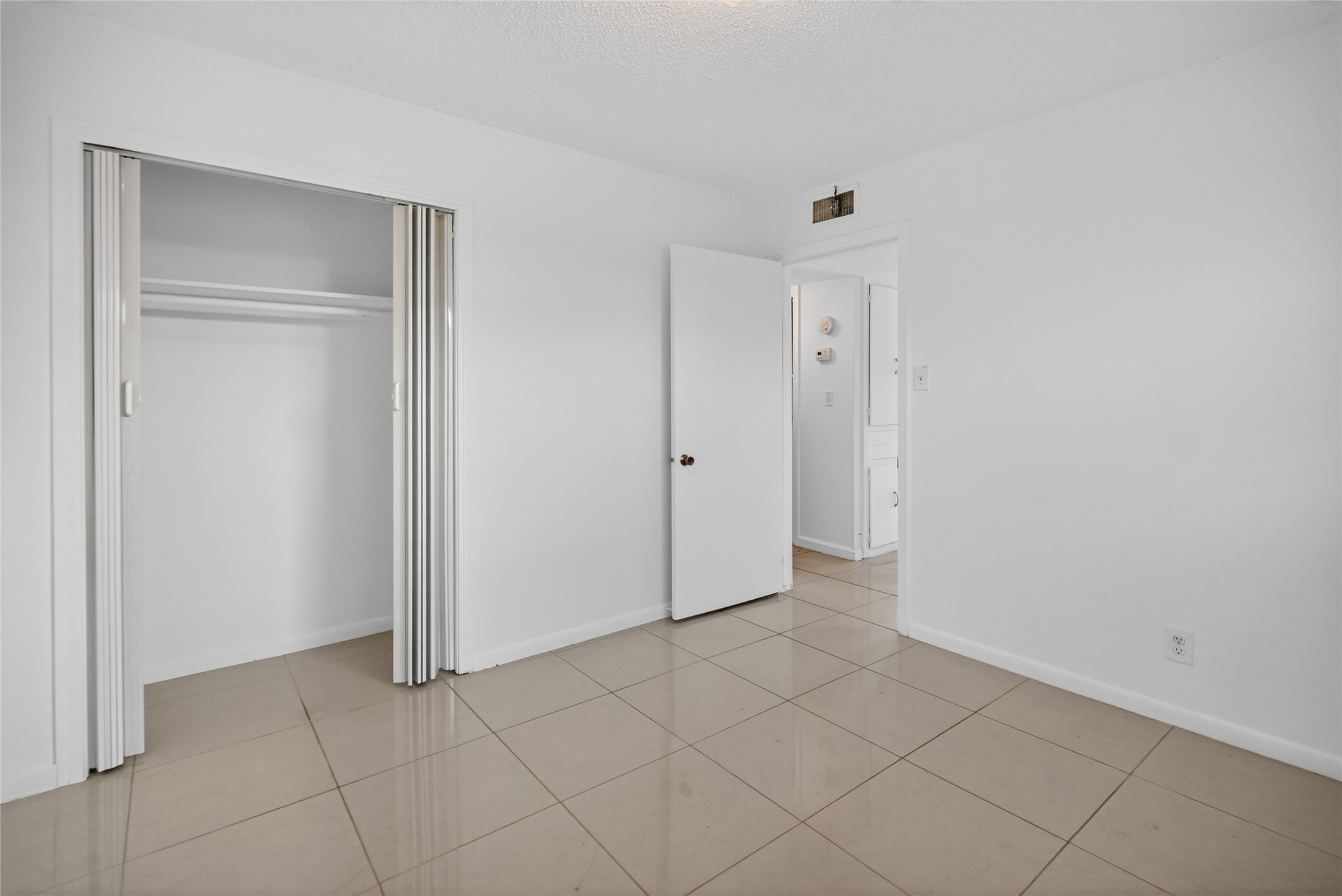 1400 Braes Ridge Drive, Unit B Austin, TX 78723 - Photo 10 of 16 Unfurnished bedroom featuring a textured ceiling, a closet, and light tile patterned floors