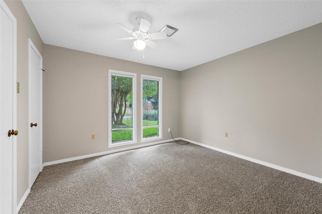 3301 Loma Vista Drive Waco, TX 76708 - Photo 17 of 29 Carpeted room featuring two white-framed windows, a ceiling fan with integrated lighting, and neutral wall tones