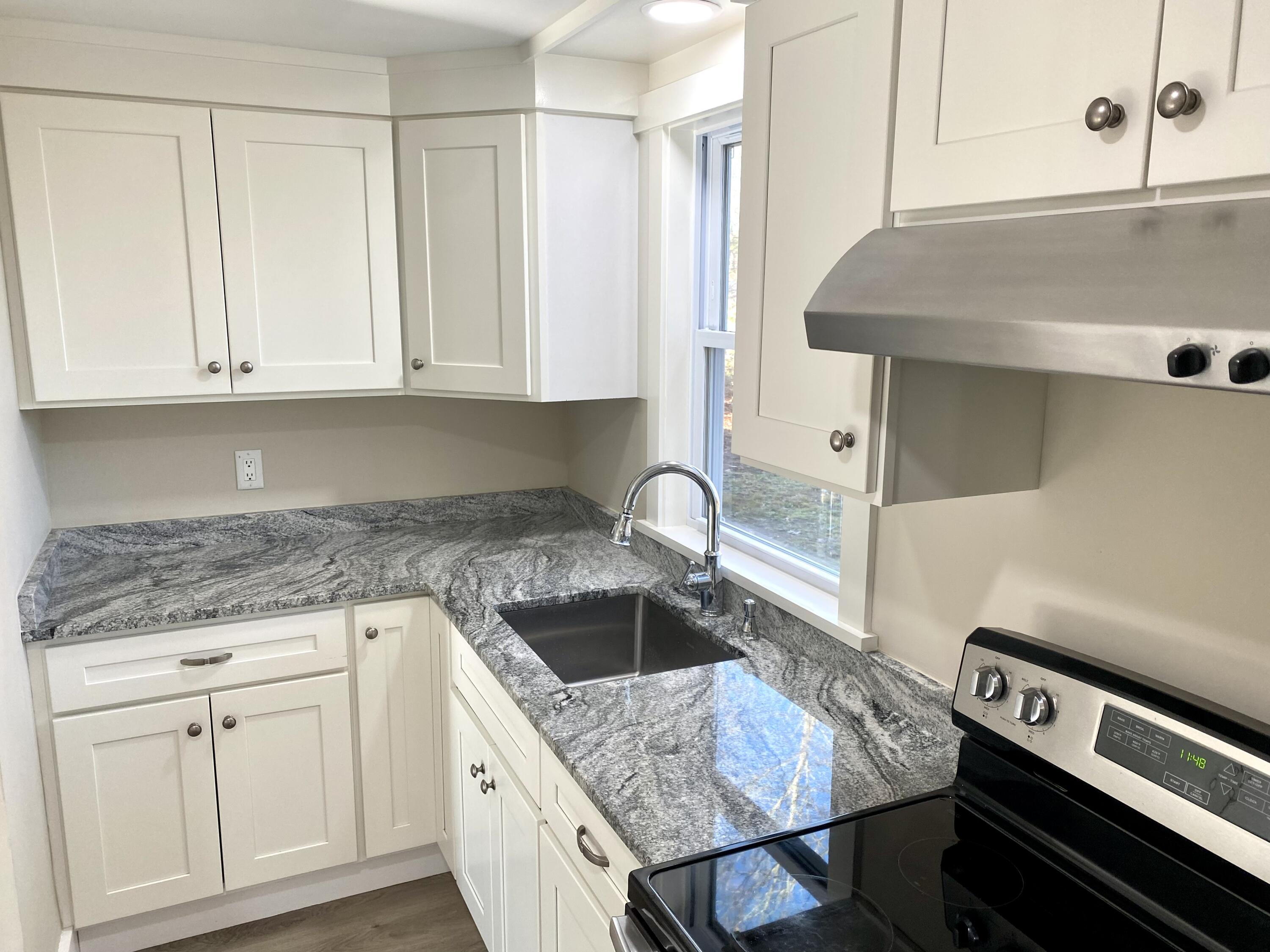 5 General Patton Drive Hyannis, MA 02601 - Photo 3 of 66 a kitchen with granite countertop a sink dishwasher a stove and a stove with wooden floor