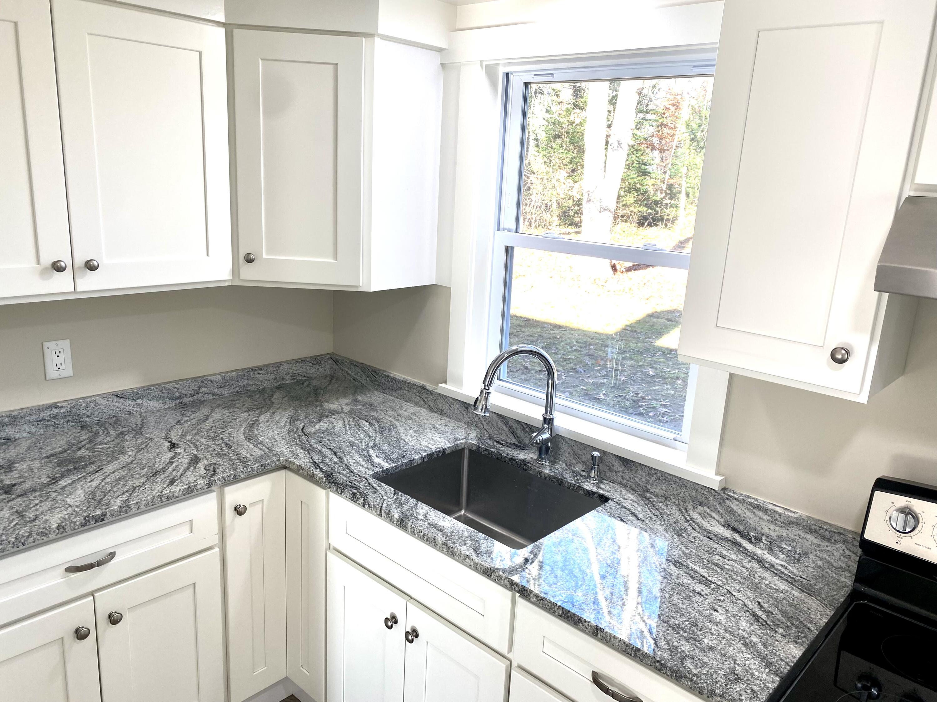 5 General Patton Drive Hyannis, MA 02601 - Photo 6 of 66 a kitchen with granite countertop a sink window and cabinets