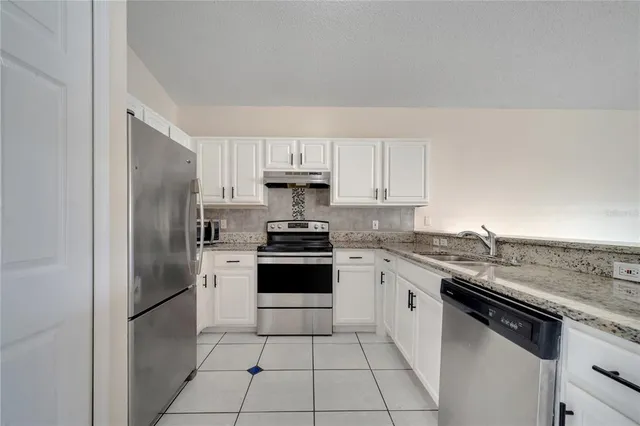 a kitchen with stainless steel appliances granite countertop a refrigerator sink and cabinets