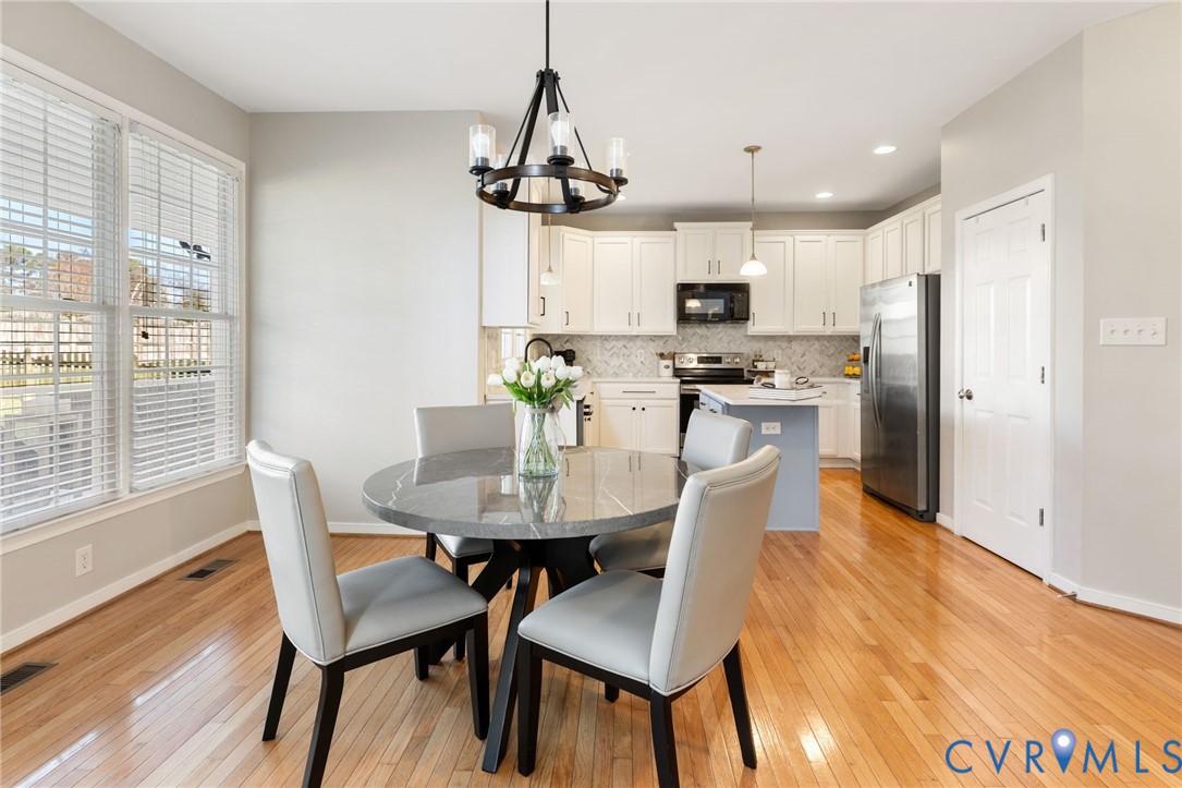 12008 Wheat Ridge Court Glen Allen, VA 23059 - Photo 13 of 36 a view of a dining room with furniture a chandelier and wooden floor