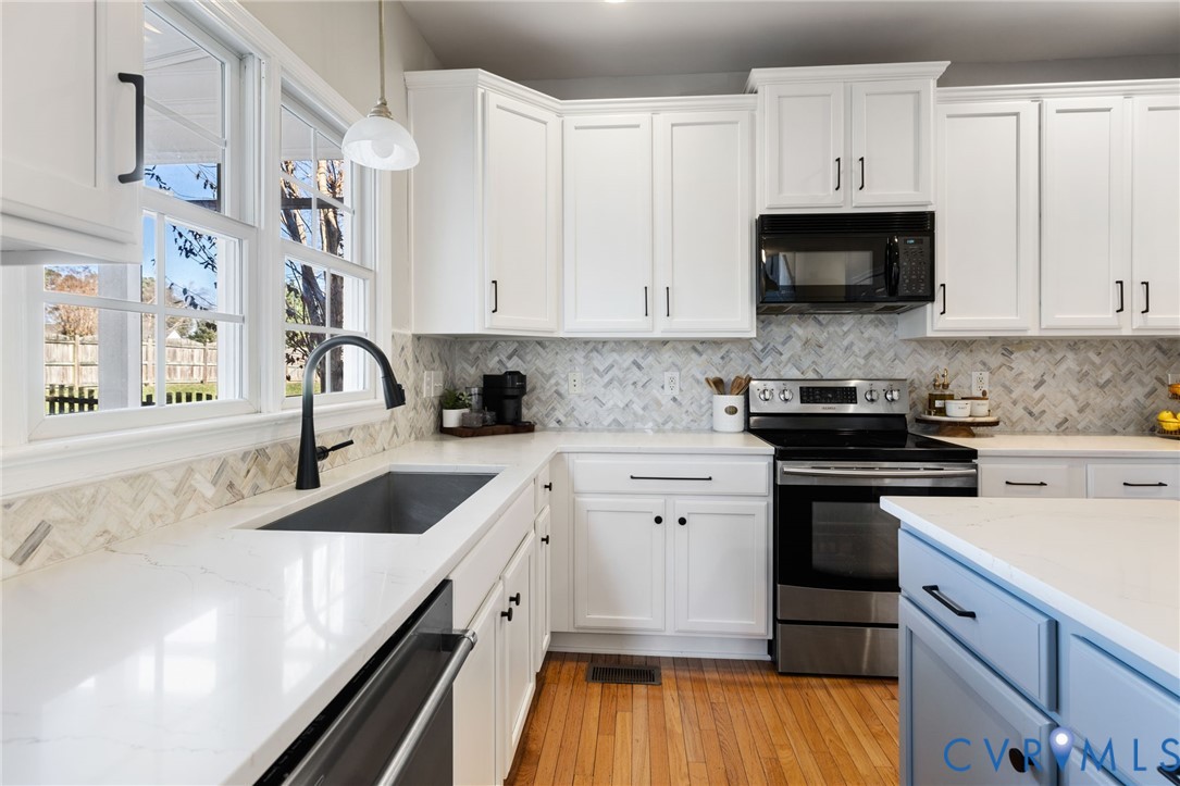 12008 Wheat Ridge Court Glen Allen, VA 23059 - Photo 16 of 36 a kitchen with granite countertop a sink dishwasher a stove and a microwave oven with cabinets