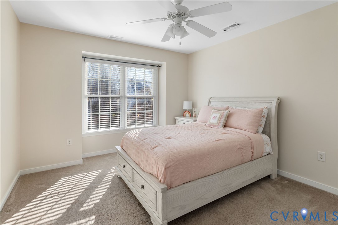 12008 Wheat Ridge Court Glen Allen, VA 23059 - Photo 19 of 36 a large bed sitting in a bedroom next to a window