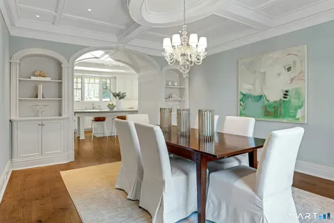a view of a dining room with furniture a chandelier and wooden floor