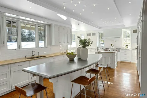 a kitchen with a table chairs sink and cabinets