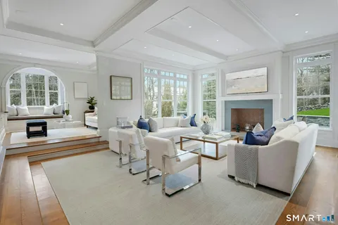 a living room with fireplace furniture and a large window
