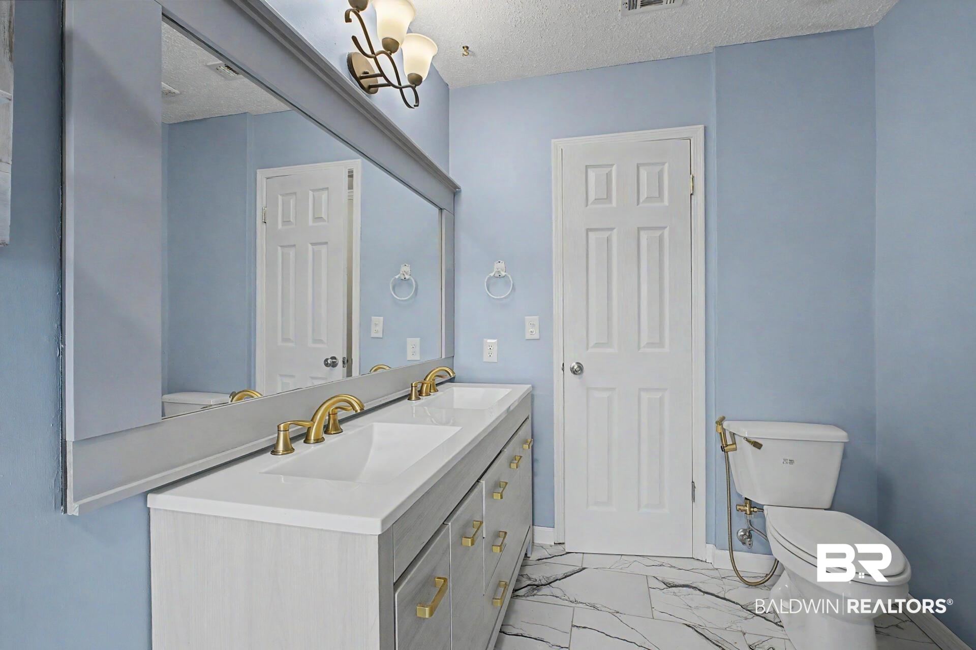 3791 Robinsonville Road Atmore, AL 36502 - Photo 39 of 47 Spacious vanity featuring dual undermount sinks, gold-finish faucets, and an expansive mirror