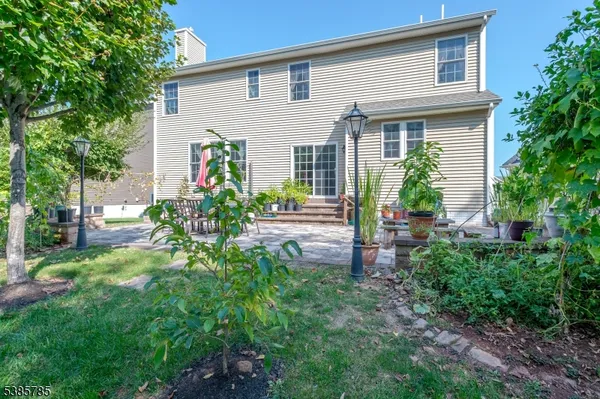 a view of house with a backyard and sitting area