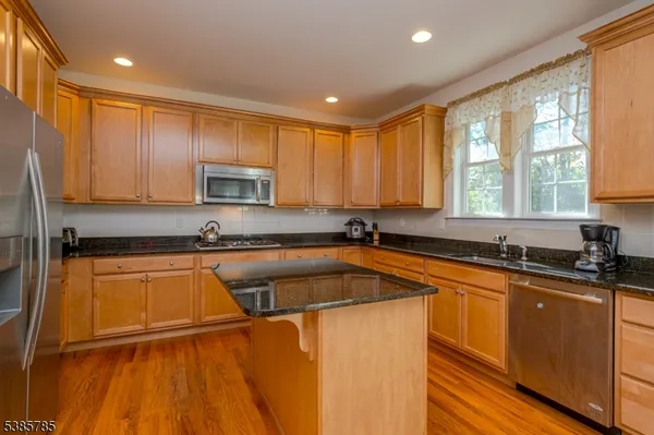 a kitchen with stainless steel appliances granite countertop a sink stove and microwave
