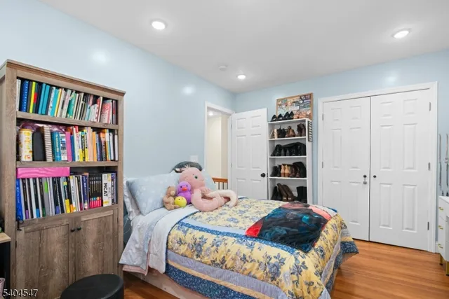 a bedroom with a bed a book shelf and a book shelf