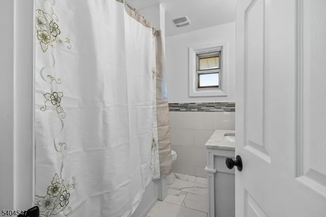 a bathroom with a shower curtain and a sink