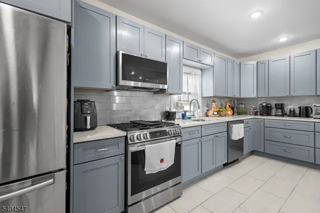 a kitchen with stainless steel appliances granite countertop a refrigerator stove a sink and a microwave