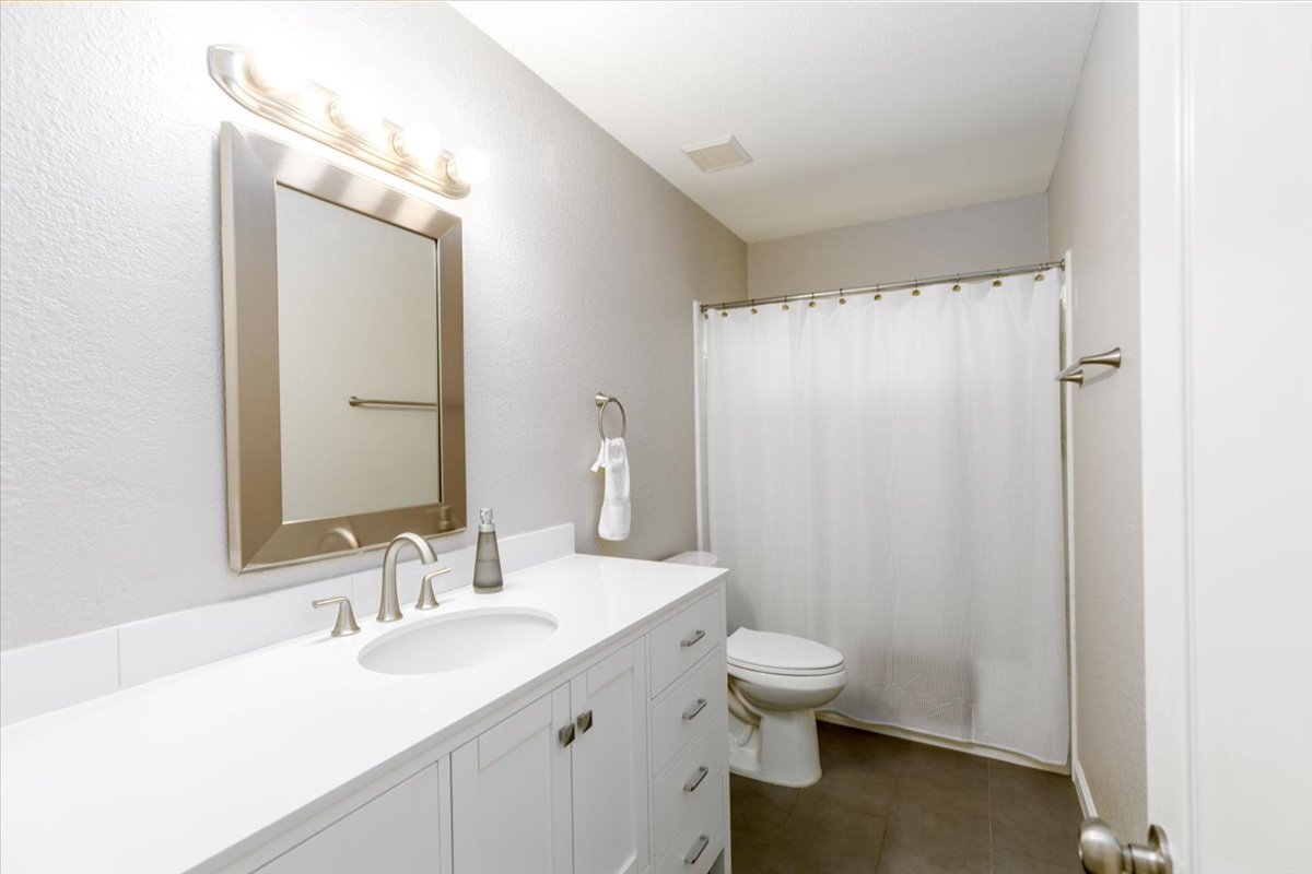 7136 Ridge Oak Road Austin, TX 78749 - Photo 16 of 28 A well-lit bathroom featuring a clean vanity and essential fixtures.