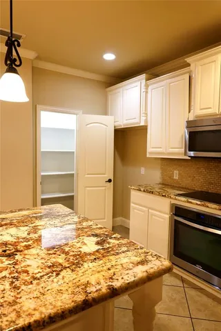 a kitchen with granite countertop a sink stainless steel appliances and cabinets