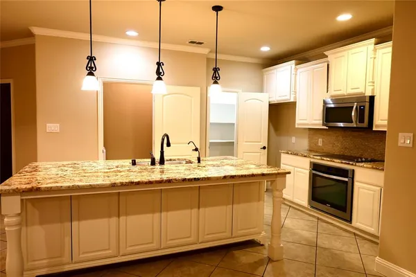 a kitchen with stainless steel appliances granite countertop a sink and stove top oven