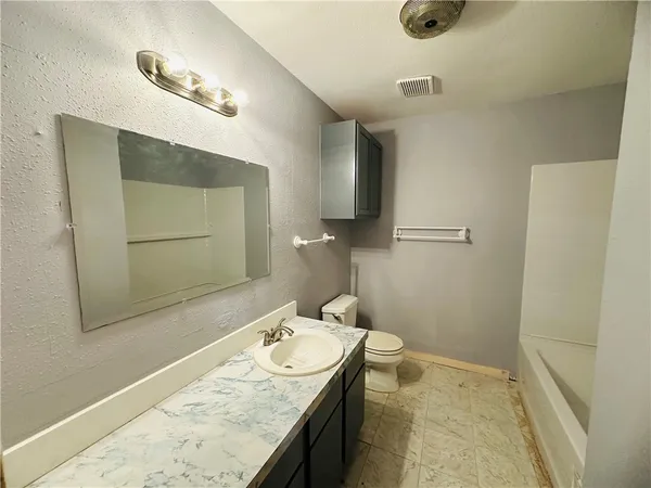 a bathroom with a granite countertop sink a mirror and shower