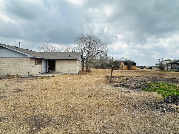 a view of a dry yard with a house