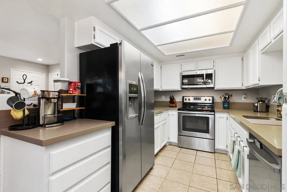 13975 Midland Road Poway, CA 92064 - Photo 12 of 33 a kitchen with granite countertop a refrigerator stove and microwave