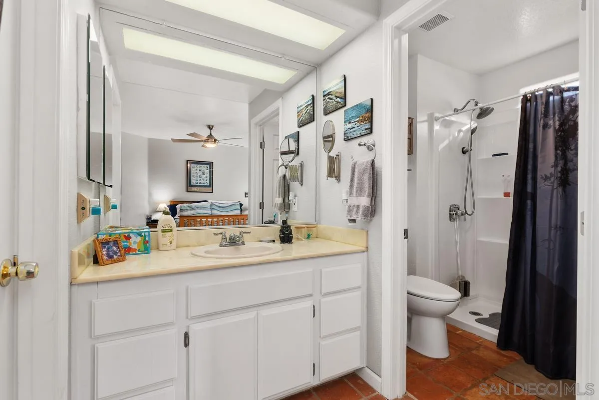 13975 Midland Road Poway, CA 92064 - Photo 19 of 33 a bathroom with a sink a toilet and a large mirror