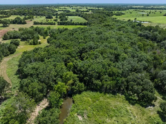 an aerial view of a houses with yard and lake view