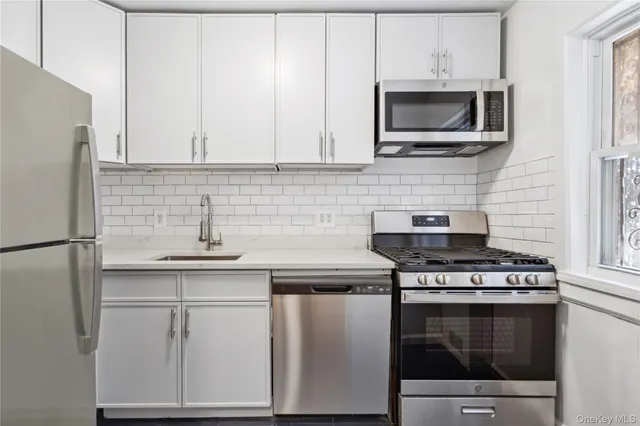 a kitchen with cabinets stainless steel appliances and a sink