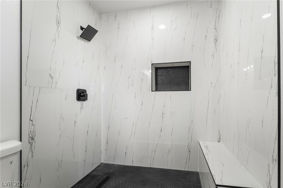 39 Lowery Street Henderson, NV 89015 - Photo 16 of 40 A well-appointed shower space showcases a built-in bench and a practical niche.