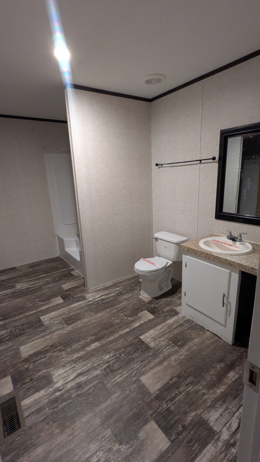 15695 Schank Road Conroe, TX 77306 - Photo 4 of 14 a bathroom with a toilet sink and mirror