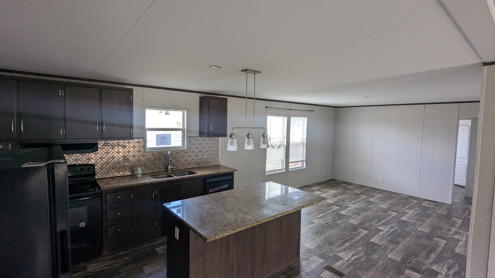 15695 Schank Road Conroe, TX 77306 - Photo 9 of 14 a kitchen with kitchen island stainless steel appliances granite countertop a sink and a refrigerator