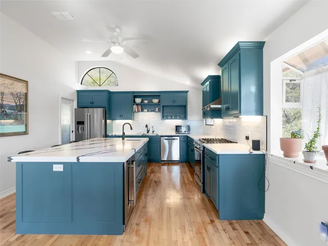 a bedroom with a large bed and wooden floor
