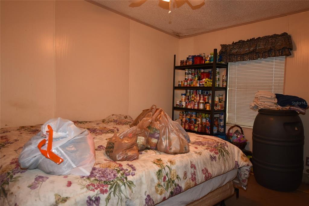 11542 Sumner Road Wimauma, FL 33598 - Photo 20 of 65 a bedroom with a bed and a book shelf