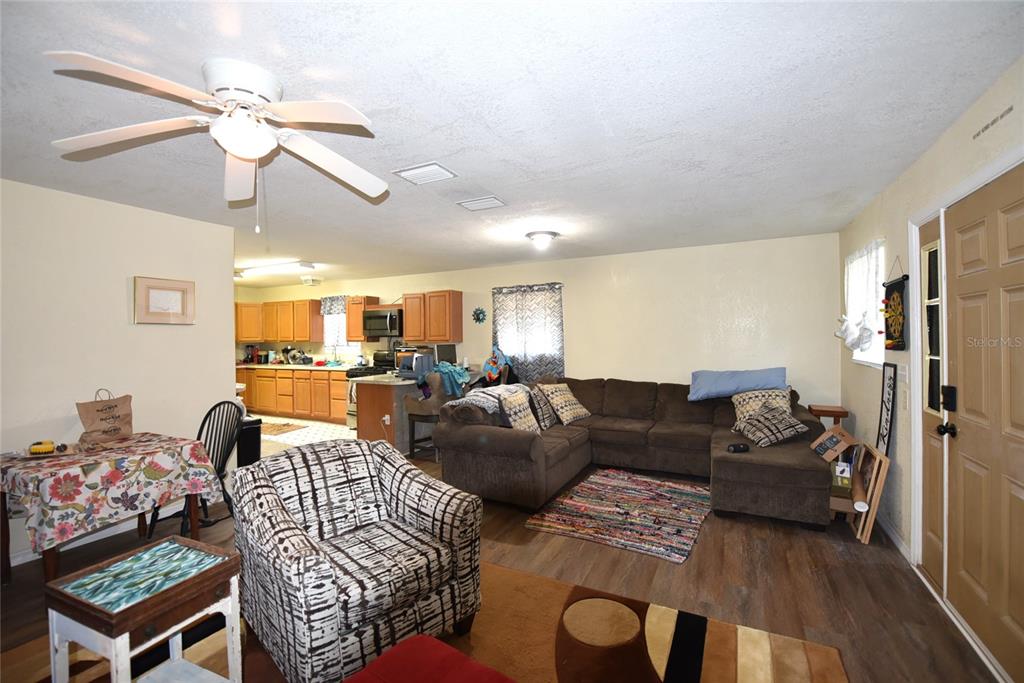 11542 Sumner Road Wimauma, FL 33598 - Photo 24 of 65 a living room with furniture a couch and a chandelier