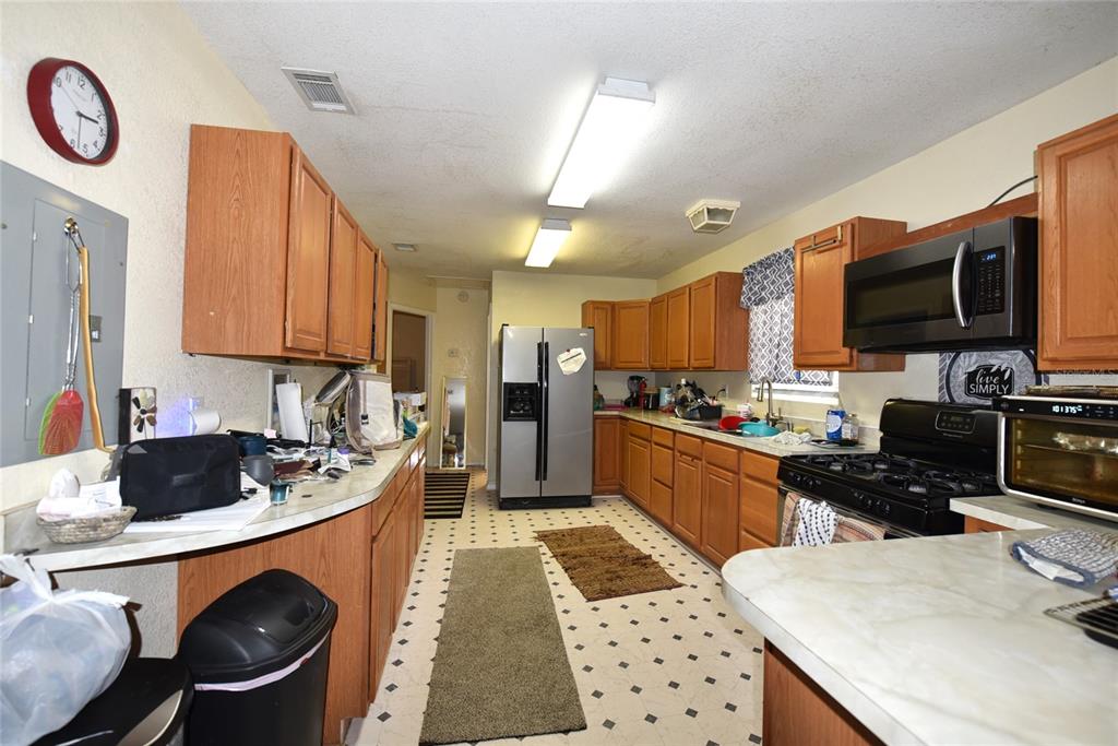 11542 Sumner Road Wimauma, FL 33598 - Photo 27 of 65 a kitchen with a sink a stove and a microwave