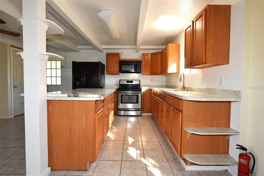 11542 Sumner Road Wimauma, FL 33598 - Photo 36 of 65 a kitchen with stainless steel appliances granite countertop a sink stove and refrigerator