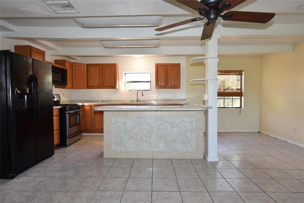 11542 Sumner Road Wimauma, FL 33598 - Photo 38 of 65 a kitchen with stainless steel appliances granite countertop a stove a refrigerator and a sink