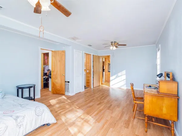 a bedroom with a bed and wooden floor
